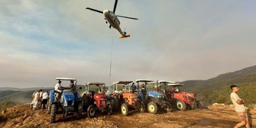 KÖYLÜLER YANGINA KARŞI SEFERBER OLDU: TANKERLERLE HELİKOPTERLERE SU TAKVİYESİ YAPILIYOR